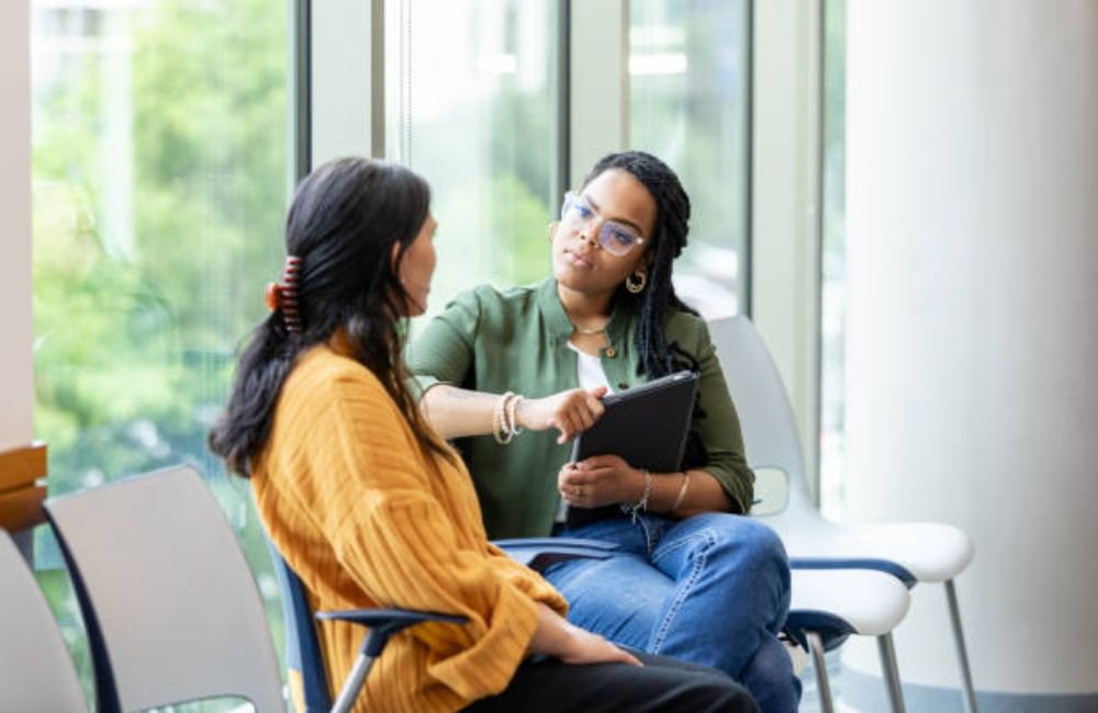 Counselor with a tablet talking with a woman during a mental health intake