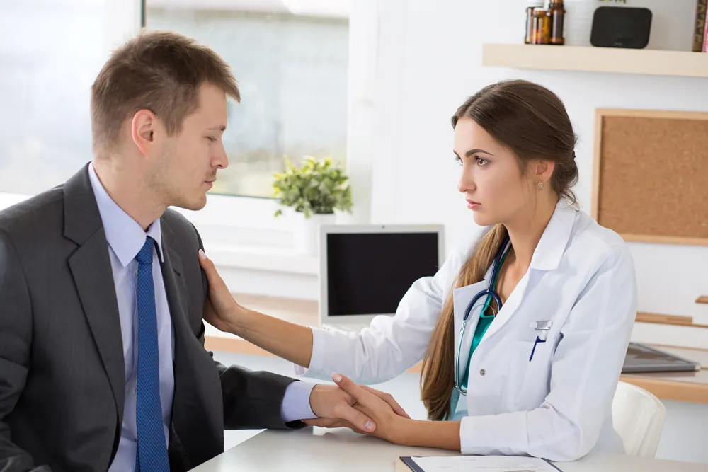 Clinician reassuring a man during a dual diagnosis treatment consultation